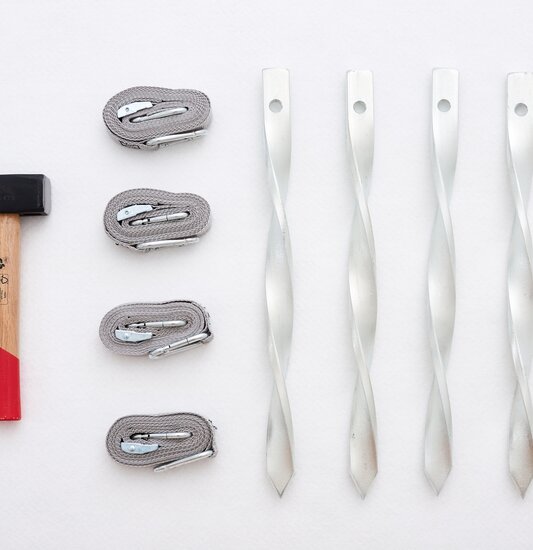 Kit di fissaggio da 4 composto da 1 martello, 4 cinghie di tensione e 4 picchetti.