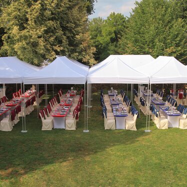 Sistema di gazebo bianchi 8x4 per un catering di un matrimonio su un prato organizzato sa Ringhotel Woerlitz