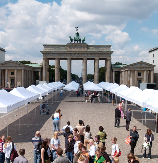 Allestimento di gazebo pieghevoli bianchi Ecotent utilizzati durante un grande evento in piazza a Berlino